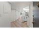 Bright entryway with wood-look floors leading to a stylish, all-white kitchen and living area at 400 E Colonial Dr # 402, Orlando, FL 32803