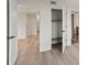 Hallway with light wood floors looking into bathroom and closet spaces, and featuring white doors at 400 E Colonial Dr # 402, Orlando, FL 32803