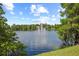 Scenic lake view featuring a fountain surrounded by lush trees and blue sky at 400 E Colonial Dr # 402, Orlando, FL 32803