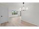 Living room featuring light wood floors, neutral walls, and a modern chandelier at 400 E Colonial Dr # 402, Orlando, FL 32803
