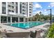 Park Lake Towers featuring a pool, lounge chairs, tables, and manicured landscaping with palm trees at 400 E Colonial Dr # 402, Orlando, FL 32803
