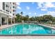 Park Lake Towers featuring a pool, lounge chairs, and manicured landscaping with palm trees at 400 E Colonial Dr # 402, Orlando, FL 32803