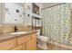 Bathroom with modern vanity, neutral stone counters, bronze fixtures, and a tub-shower combo with floral curtain at 4927 Fiske Cir, Orlando, FL 32826