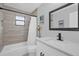 Modern bathroom features include a new vanity, framed mirror, tiled walls and shower over the tub at 508 Boxelder Ave, Altamonte Springs, FL 32714