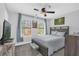 A beautifully staged bedroom with a ceiling fan, two windows with drapes, a queen-size bed and carpeted floors at 508 Boxelder Ave, Altamonte Springs, FL 32714
