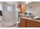Bathroom with a tub, window, vanity with counter space, and a mirror at 6107 Metrowest Blvd # 104, Orlando, FL 32835