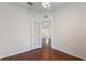 Bright secondary bedroom with an open doorway to a living space with hardwood floors at 6107 Metrowest Blvd # 104, Orlando, FL 32835