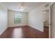Bright bedroom with hardwood floors, ceiling fan, and an entrance to a stairwell at 6107 Metrowest Blvd # 104, Orlando, FL 32835