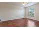 Bedroom featuring wood floors, a ceiling fan, and a large window providing natural light at 6107 Metrowest Blvd # 104, Orlando, FL 32835