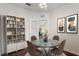 Cozy dining area with round table, chairs, bookcase and modern artwork at 6107 Metrowest Blvd # 104, Orlando, FL 32835