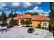 Community clubhouse featuring tile roof, decorative entrance, and ample parking at 6107 Metrowest Blvd # 104, Orlando, FL 32835
