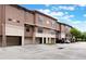 Shot of townhomes with tandem two-car garages, stone facade, and well-maintained landscaping at 6107 Metrowest Blvd # 104, Orlando, FL 32835