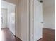 Hallway with a view to bedrooms and closets, featuring hardwood flooring and white trim at 6107 Metrowest Blvd # 104, Orlando, FL 32835