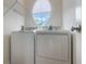 Laundry room featuring a washer, dryer, shelving, and a unique circular window at 6107 Metrowest Blvd # 104, Orlando, FL 32835