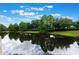 Community pond reflecting the clouds with trees surrounding it at 6107 Metrowest Blvd # 104, Orlando, FL 32835