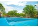 Community tennis court with net and backdrop of mature trees and buildings at 6107 Metrowest Blvd # 104, Orlando, FL 32835