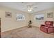 Sunny bedroom featuring two windows, plush carpeting, and a comfortable armchair for relaxation at 806 Bear Lake Rd, Apopka, FL 32703