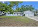 Charming single-story light blue home with an attached two-car garage and mature landscaping in the front yard at 806 Bear Lake Rd, Apopka, FL 32703