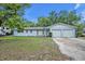 Charming single-story light blue home with an attached two-car garage and mature landscaping in the front yard at 806 Bear Lake Rd, Apopka, FL 32703