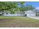 Charming single-story light blue home with an attached two-car garage, flower beds, and mature landscaping in the front yard at 806 Bear Lake Rd, Apopka, FL 32703