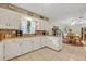Open kitchen layout with white cabinetry, mosaic backsplash, and an adjacent dining area enhancing the home's flow at 806 Bear Lake Rd, Apopka, FL 32703
