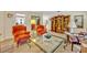 Inviting living room showcasing carpet floors, vintage furniture, a bookshelf, and a partial view of the kitchen at 806 Bear Lake Rd, Apopka, FL 32703