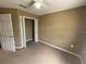 An empty carpeted bedroom with white door and closet at 8417 Leeland Archer Blvd, Orlando, FL 32836