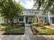 Charming two-story townhouse with inviting landscaping, including green shrubs and trees framing the entrance at 8417 Leeland Archer Blvd, Orlando, FL 32836