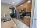 Well-equipped kitchen featuring stainless steel appliances, tile backsplash, and a view into the cozy living area at 8417 Leeland Archer Blvd, Orlando, FL 32836