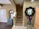 View of carpeted staircase with decor on the wall and gray storage bench with throw pillows at the base of the stairs at 8417 Leeland Archer Blvd, Orlando, FL 32836