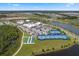 Aerial view of neighborhood amenities, including tennis courts, shuffleboard, and a sparkling lake at 867 Bama Breeze Dr, Daytona Beach, FL 32124