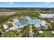 Community aerial view of the resort-style pool area with palm trees, umbrellas, and lounge chairs at 867 Bama Breeze Dr, Daytona Beach, FL 32124