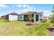 Well-manicured backyard with a screened lanai and lush green lawn at 867 Bama Breeze Dr, Daytona Beach, FL 32124