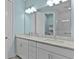 Bathroom featuring double sinks with granite countertops, large mirror and tiled shower with glass doors at 867 Bama Breeze Dr, Daytona Beach, FL 32124