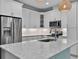A close up of an island with an undermount sink, stainless appliances, and granite counters at 867 Bama Breeze Dr, Daytona Beach, FL 32124