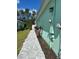 Sideyard view showing lush landscaping and paver pathway along the property line at 867 Bama Breeze Dr, Daytona Beach, FL 32124