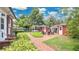 Beautiful backyard with brick patio, seating, outbuildings and lush green grass and plantings at 900 S Palmetto Ave, Sanford, FL 32771