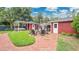 Inviting backyard with brick patio, outdoor seating, a pergola, and lush green landscaping at 900 S Palmetto Ave, Sanford, FL 32771
