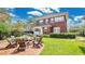 Backyard view with brick firepit, seating, manicured lawn, and mature shade trees at 900 S Palmetto Ave, Sanford, FL 32771