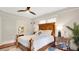 Bedroom with a wooden bed frame, decorative light fixture, hardwood floors, and natural light from windows at 900 S Palmetto Ave, Sanford, FL 32771
