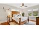 Bedroom featuring a wooden bed frame, hardwood floors, multiple windows, and unique decor at 900 S Palmetto Ave, Sanford, FL 32771