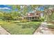 Beautiful property featuring a lush green lawn, mature trees, and charming exterior details at 900 S Palmetto Ave, Sanford, FL 32771