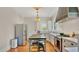 Well-lit kitchen with stainless steel appliances, white cabinetry, modern island, and hardwood flooring at 900 S Palmetto Ave, Sanford, FL 32771