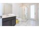 Modern bathroom with a glass shower, black vanity, white toilet and white tile floor at 9038 Sunshine Ridge Loop, Kissimmee, FL 34747