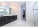 Bright bathroom featuring a glass-door shower, tile flooring, and vanity with double sinks at 9038 Sunshine Ridge Loop, Kissimmee, FL 34747