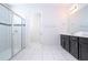 Bright bathroom featuring a glass-door shower, tile flooring, and vanity with double sinks at 9038 Sunshine Ridge Loop, Kissimmee, FL 34747