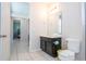 Well-lit bathroom with black vanity and white toilet, featuring a large mirror and white towels at 9038 Sunshine Ridge Loop, Kissimmee, FL 34747