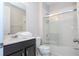 Bright bathroom featuring a shower-tub combination with sliding glass doors and a dark vanity with a white countertop at 9038 Sunshine Ridge Loop, Kissimmee, FL 34747
