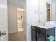 Bright bathroom featuring a dark vanity with a white countertop, mirror, and next to a laundry room at 9038 Sunshine Ridge Loop, Kissimmee, FL 34747