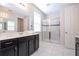 Modern bathroom with a glass-enclosed shower, dual vanity, and tiled floors at 9038 Sunshine Ridge Loop, Kissimmee, FL 34747
